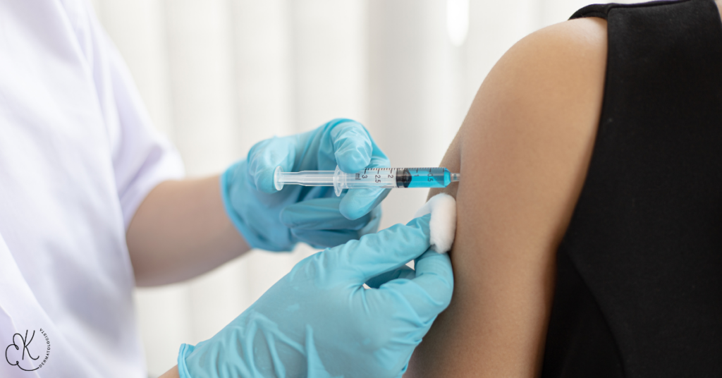 Profissional de saúde aplicando uma injeção no braço de um paciente para tratamento da psoríase.