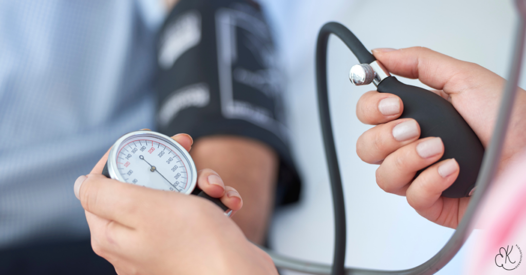 Pessoa medindo a pressão arterial com esfigmomanômetro durante uma consulta médica